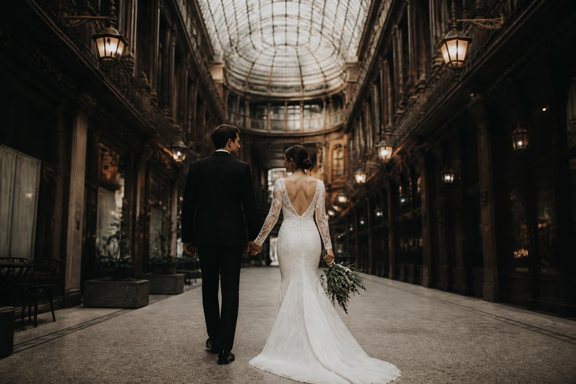 A couple walking through a historic Cleveland arcade on their wedding day